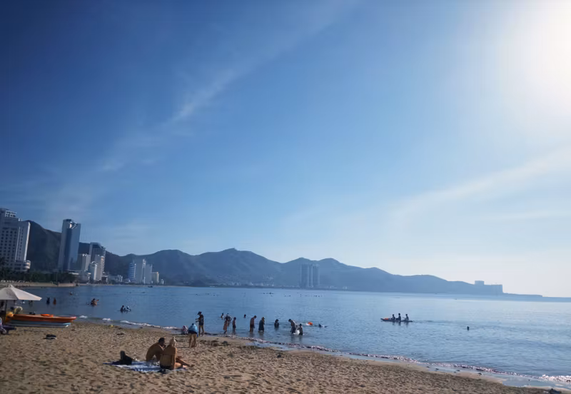 Nha Trang beach in early morning with swimmers and a kayak