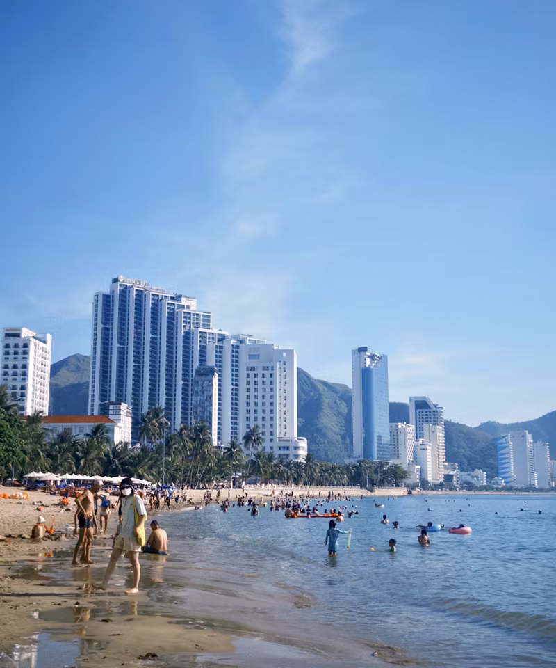 Crowded Nha Trang beach with high-rise hotels behind it